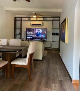 a living room with a dining table and a tv at Estancia Calafia in Los Pozos