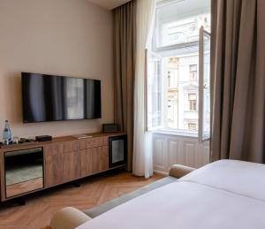 a hotel room with a flat screen tv and a window at LOVIS Suites Vienna in Vienna
