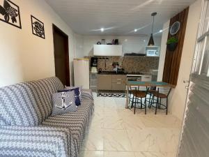 a living room with a couch and a table and a kitchen at Casa de praia Rocha Alves em Porto de Galinhas in Porto De Galinhas