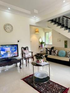 a large living room with a tv and a couch at Amber- Sun-Kissed Holidays, Goa in Chicalim