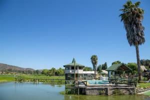 Las CabrasCabañas Villa Alejandra的水体上的房子