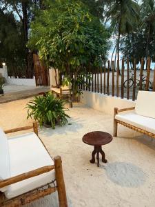 a bench and a coffee table in the sand at Paje Beach Front villa by Liv Zanzibar in Paje