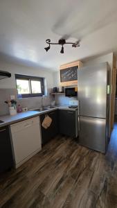 a kitchen with a refrigerator and a counter top at Le Chant des Arbres in Grane