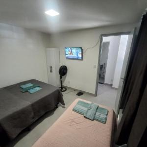 巴西利亚Apartamento 1 quarto Asa Norte prédio misto - residencial comercial - wi-Fi - 1 a 3 hospedes - sem taxas的一间卧室设有两张床,墙上配有电视。