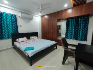 une chambre avec un lit, une table et un miroir dans l'établissement Cozy 3BHK Stay Near US Consulate, Nallagandla, à Hyderabad