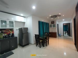 une cuisine et une salle à manger avec une table et un réfrigérateur dans l'établissement Cozy 3BHK Stay Near US Consulate, Nallagandla, à Hyderabad