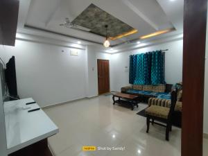 un salon avec deux chaises et un canapé dans l'établissement Cozy 3BHK Stay Near US Consulate, Nallagandla, à Hyderabad