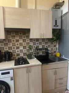 a kitchen with wooden cabinets and a stove top oven at Bella in Tbilisi City +12 photos