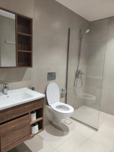 a bathroom with a shower and a toilet and a sink at Muscat City Stay-2BR Apt 108 near Grand & Avenue Mall in Ghubrah
