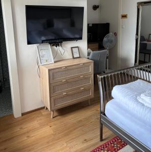 a bedroom with a dresser with a flat screen tv at Gästezimmer Schwaz Panorama in Schwaz +1 photo