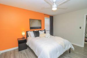 a bedroom with an orange wall and a bed at Reservoir Modern 3BR Home in Brandon