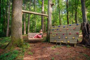 a woman sitting on a bench in the woods at Saluda Summit Cabin at Cabin Fever in Saluda