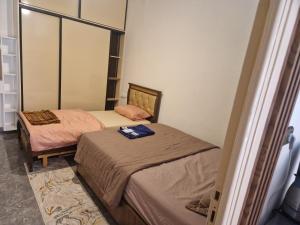 two twin beds in a room with a mirror at Nour Alkindi Nador in Nador +6 photos