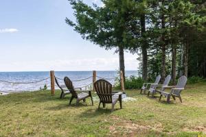 a group of chairs sitting next to the water at Adventure & Relaxation by Lake Superior in Paradise
