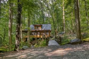 een blokhut in het bos met een loopbrug bij Multiple cabins at Cabin Fever in Saluda