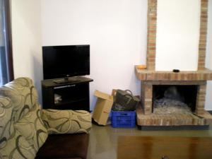 Una sala de estar con chimenea y televisión. en villa Manuel, en Arcos de la Frontera