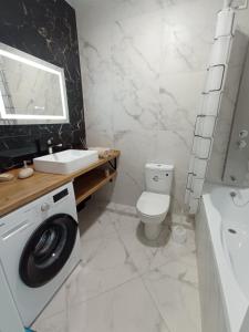 a bathroom with a toilet and a sink and a washing machine at ЖК Dream Town, Lutsk in Lutsk +14 photos