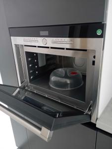 ルツカイにあるЖК Dream Town, Lutskのキッチンにあるドアが開いた電子レンジ