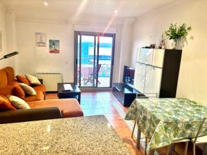a living room with a couch and a refrigerator at Portosin Sea&Pool in Portosin
