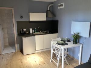 una cucina con tavolo e una piccola cucina con lavandino di Cisy Resort I -bon turystyczny,teren na wyłączność,150 m od jeziora a Makosieje