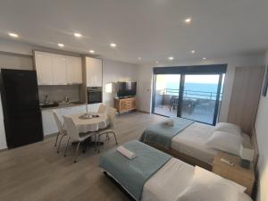 a bedroom with two beds and a table and a kitchen at Apartment Hortenzija in Baška Voda