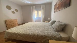 una camera da letto con un letto, un comò e una finestra di El Jade - Guada Apartamento a Valle Gran Rey