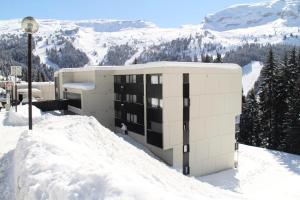 un edificio in cima a una montagna innevata di Résidence Verseau - Appartement lumineux et spacieux · Centre station · avec cabine et Balcon MAE-7781 a Magland