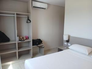 a bedroom with a white bed and a air conditioner at Salinas Park Resort in Salinópolis