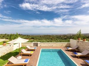 a villa with a swimming pool and patio furniture at New villa with private pool, privacy, near sea and Arkadi monastery on NW coast in Roúpai