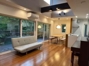 軽井沢町にある晴耕雨読の家#Outlet#Karuizawa station10mins by car#Wifi&Max11ppl#Pet OK#BBQのソファとテーブルのあるリビングルーム
