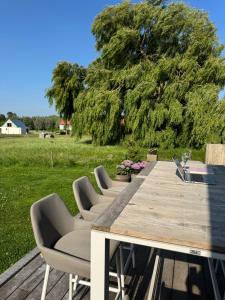 a long wooden table with chairs and a field at Koekeloeren in Hooglede