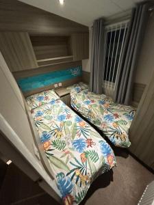 リルにあるLyons Robin Hood - 3 Bedroom Static Caravanの部屋にベッドが2つある寝室 +3枚の写真