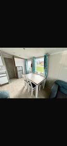 リルにあるLyons Robin Hood - 3 Bedroom Static Caravanのテーブルと椅子のあるダイニングルーム