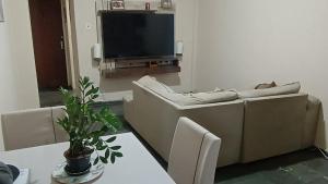 ein Wohnzimmer mit Sofa und Fernseher in der Unterkunft Quarto ao lado da praça da Liberdade in Belo Horizonte