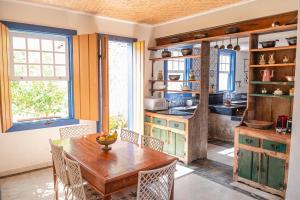 a kitchen with a wooden table and chairs at Maravilhosa Casa Mineira in Tiradentes