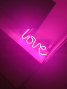 a neon sign that says exit on a purple wall at casa lidia in Brăila +1 photo