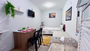 um quarto com 2 camas e uma secretária com uma mesa em Pousada Recanto do Aconchego - 7 minutos do aeroporto de Congonhas em São Paulo