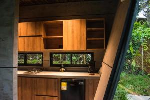 a kitchen with wooden cabinets and a black refrigerator at Primitivo Quindío in Circasia