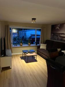 a living room with a couch and a table at Familiechalet Vechtdal in Diffelen +7 photos