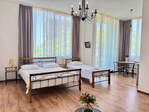 a bedroom with two beds and a table and chairs at Sun Line Hotel Kobuleti in Kobuleti