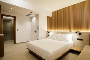 a bedroom with a large white bed and a bathroom at Thea Experience in Litochoro