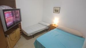 een kamer met 2 bedden en een flatscreen-tv bij Habitacin 2 personas Toledo in Las Nieves