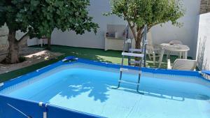 een blauw zwembad met een stoel en een tafel bij Habitacin 2 personas Toledo in Las Nieves