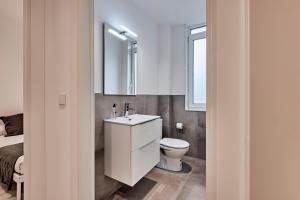 a bathroom with a toilet and a sink and a mirror at San vicente in A Coruña +54 photos