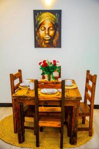 a wooden table with chairs and a statue of a woman at Warm Haven in Dar es Salaam