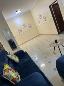 a living room with a blue couch and a table at Al appartement in Cotonou