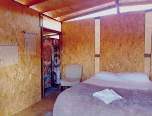 a bedroom with a bed and a chair in it at Hostel con huerta en la montaña in San José del Cabo