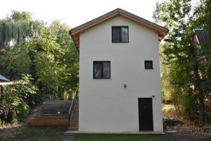 a white house with a black door and windows at Miling Vendégház in Földes