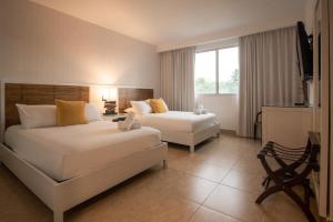a hotel room with two beds and a couch at Beach Apartment At Nikki Residences 2 Bedroom in El Chirú +41 photos