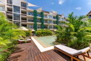 a hotel with a swimming pool in front of a building at Bakal Studios in Tulum